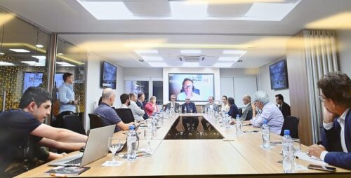 grupo de pessoas sentadas em torno de uma mesa em uma sala de reuniões