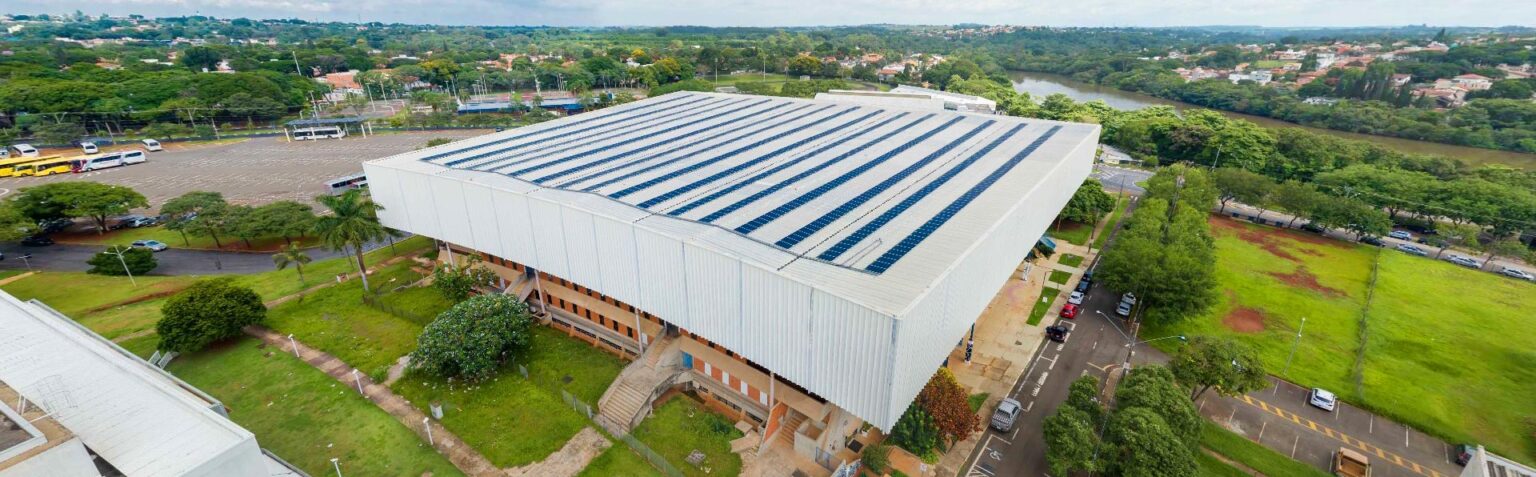 Imagem do ginásio multidisciplinar da Unicamp, com destaque para placas fotovoltaicas no telhado